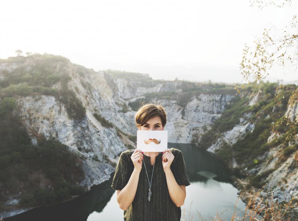 Free Image of A young caucasian woman posing with mustache shaped paper cutout 