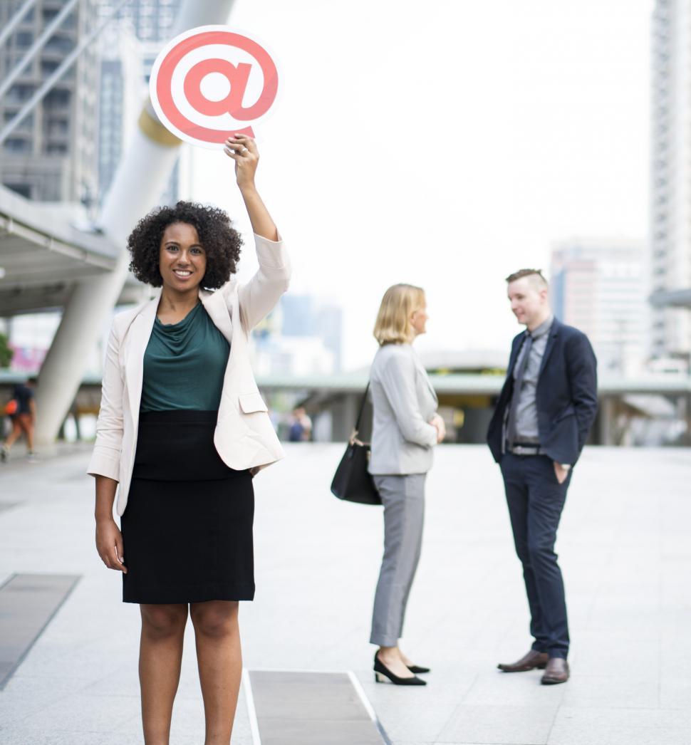 Free Image of A young with curly hair holds a cardboard at sign 