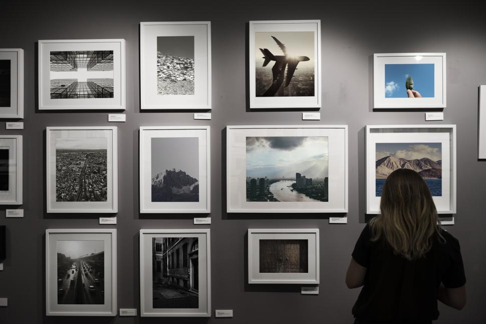 Free Image of Rear view of a woman looking at framed photograph on an exhibiti 