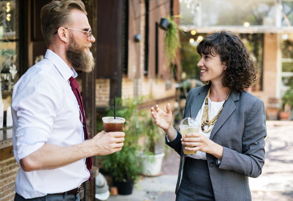 Free Image of Two business people discussing while drinking cold beverage 