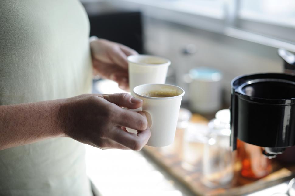 Free Image of Close up of hands holding coffee in paper cups 