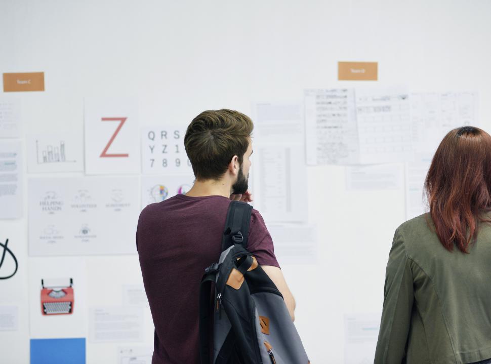 Free Image of Back view of a young man and a woman looking at the charts 
