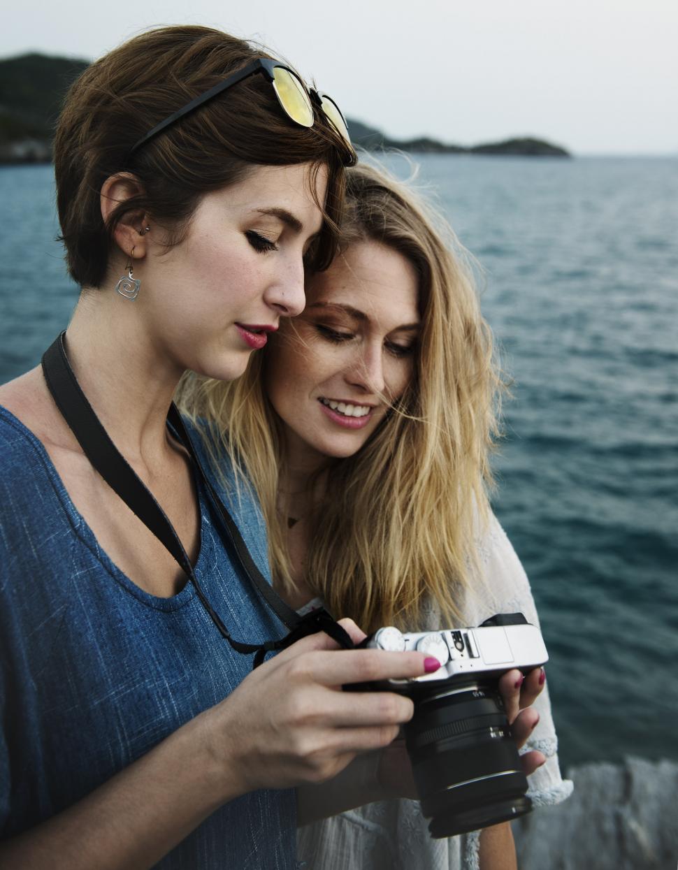Free Image of Two young women looking at their photograph on the cam 