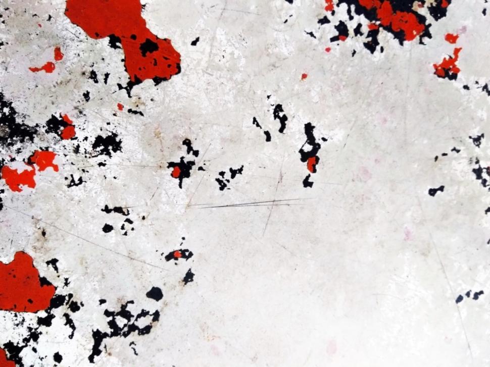 Free Image of Abstract scratched metal texture with random red and white paint patches  