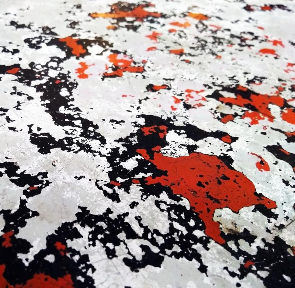 Free Image of Scratched metal texture with random red and white paint patches  