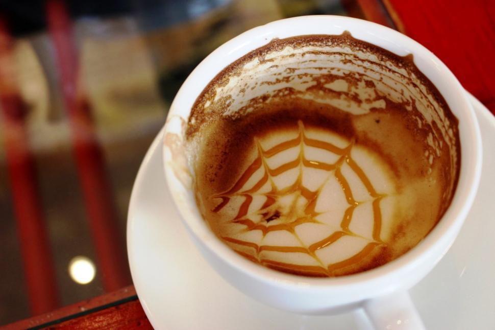 Free Image of An empty coffee cup with the froth art pattern still in the bottom  