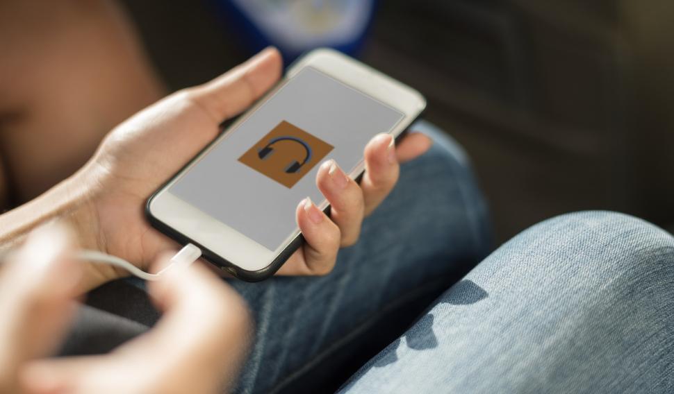Free Image of Close up a mobile phone in a hand being charged by connecting a 
