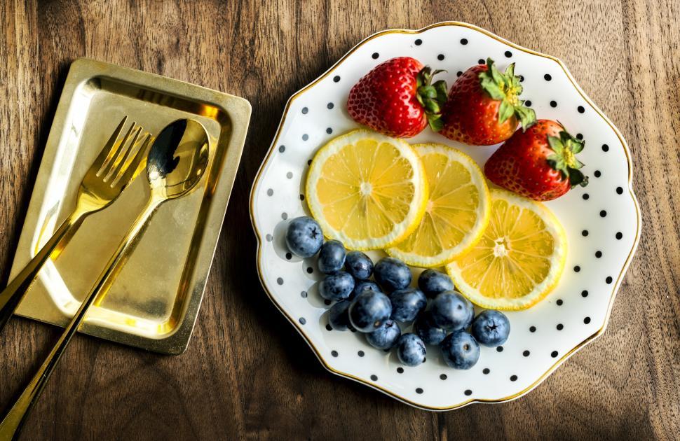 Free Image of Flat lay of strawberries, lemon slices and black grapes 