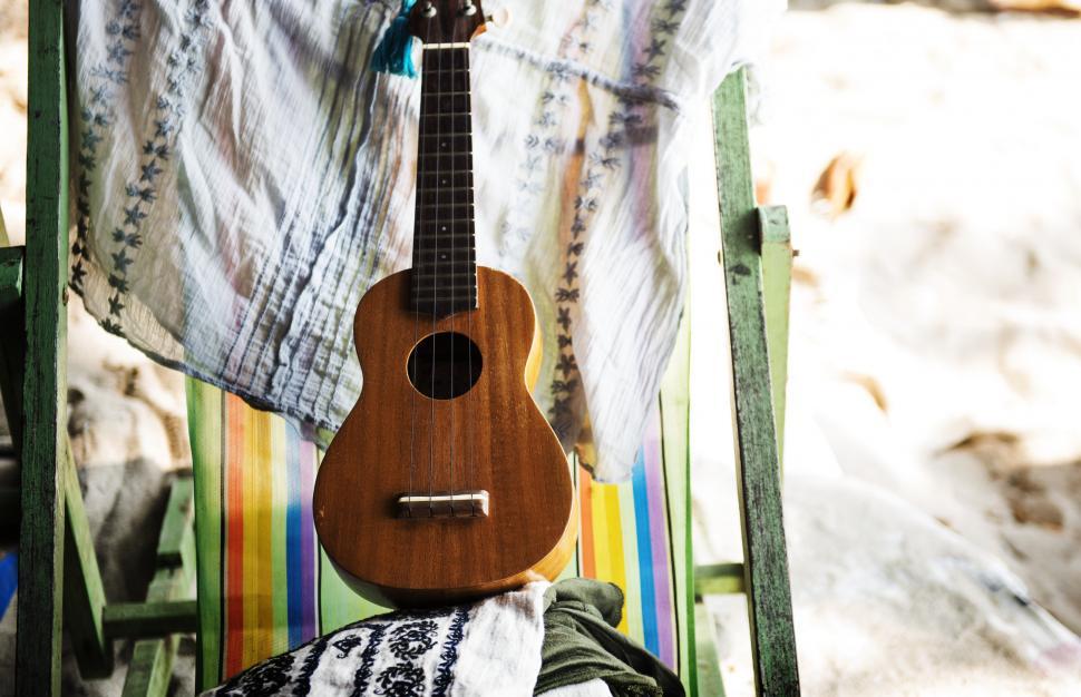 Free Image of Close up of a guitar on a beach chair 