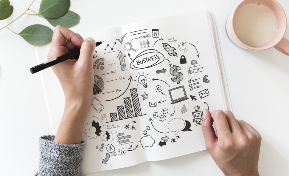Free Image of Overhead view of financial symbols being drawn on white not 