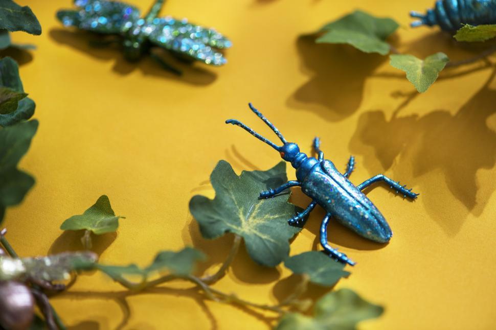 Free Image of A toy cockroach sitting on yellow surface 