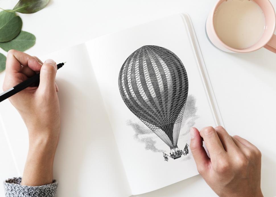 Free Image of Over the head view of a hand drawing on a sketch book 