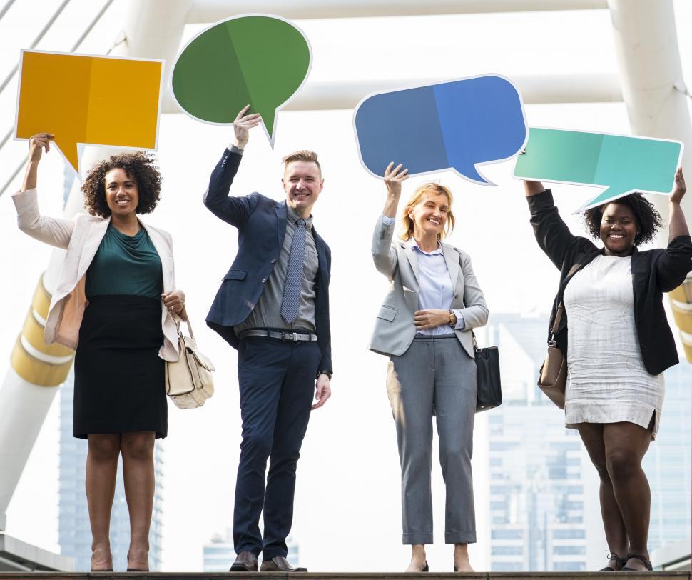 Free Image of A group of multiethnicity colleagues raising cardboard speech bu 
