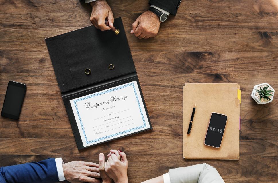 Free Image of Flat layout of a marriage certificate with a couple s hand in ha 