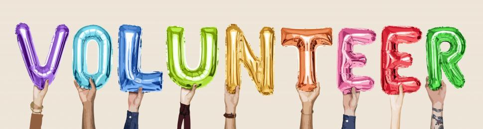 Free Image of Word  VOLUNTEER  formed by holding inflated alphabet shaped balloons with hands 