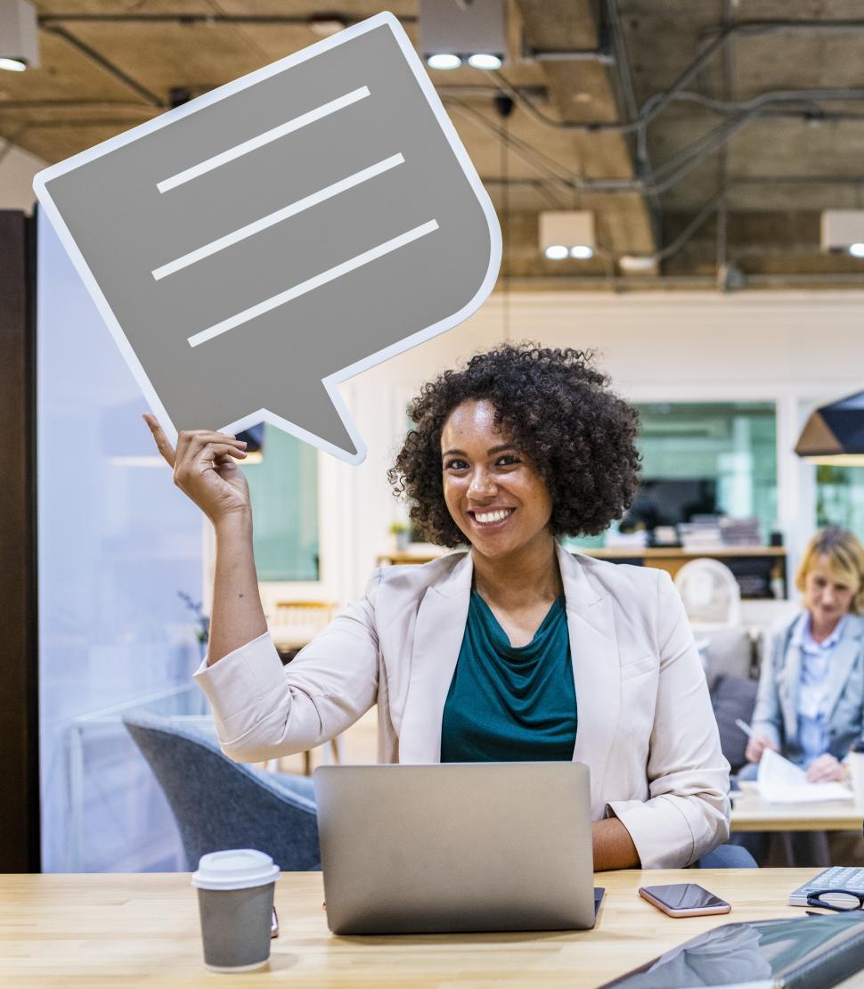 Free Image of A young African ethnicity woman with curly hair holds a speech bubble cardboard cutout 