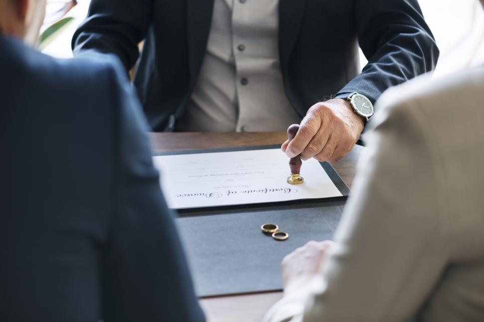 Free Image of Certificate of divorce being attested by a judge in front on former spouses 