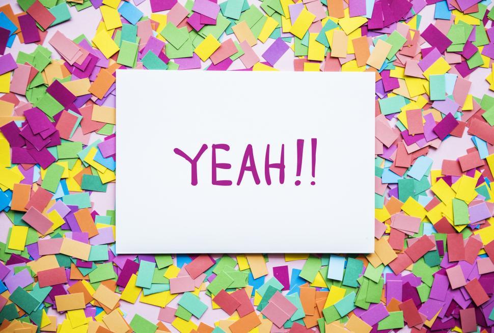 Free Image of Flat lay of the text YEAH!! written on white card surrounded with confetti 