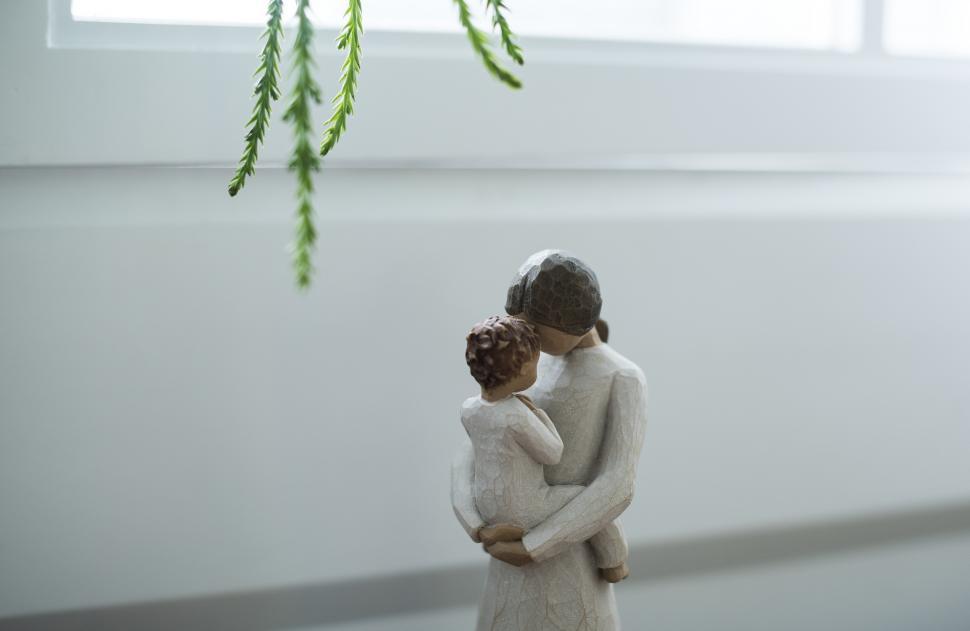 Free Image of A Stone sculpture of a mother holding a baby 