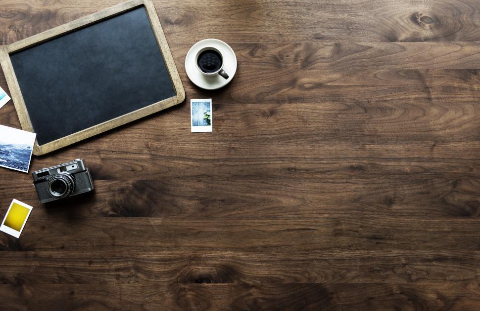 Free Image of Flat lay of a slate blackboard and vintage camera on hardwood surface 