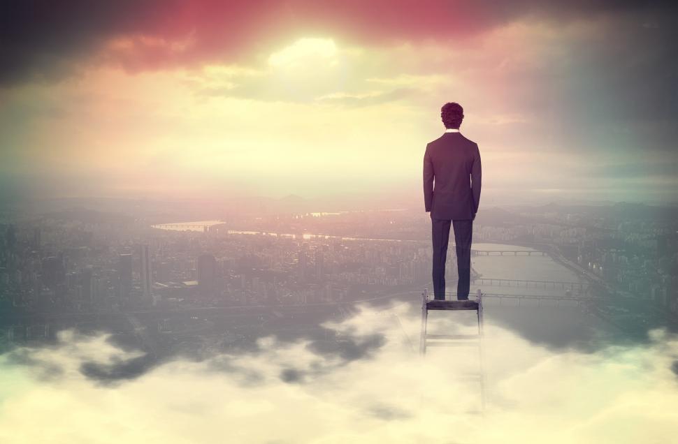 Free Image of Businessman On Top of Ladder Overlooking Cityscape 