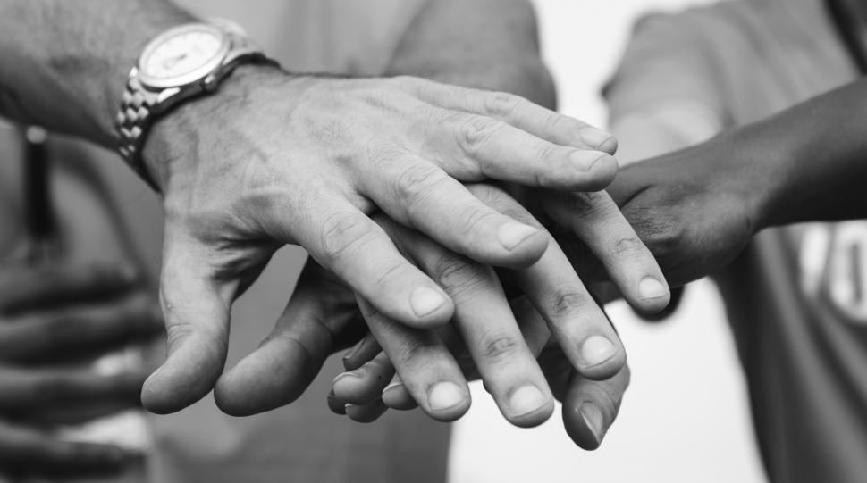 Free Image of Hands stacked together - black and white 