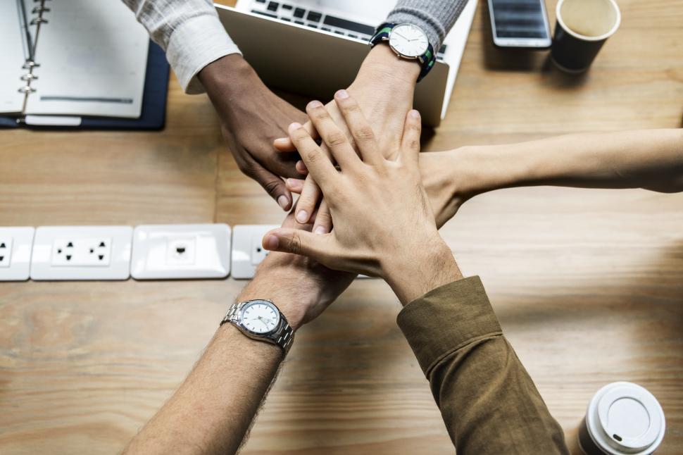 Free Image of Hands all in over conference table 