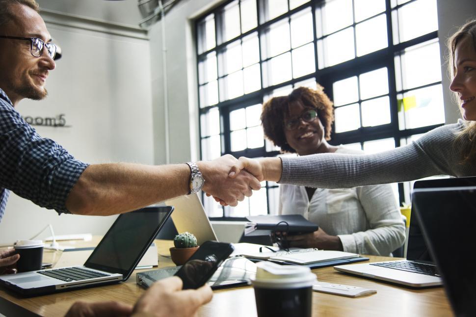 Free Image of Two business people shake across a table 