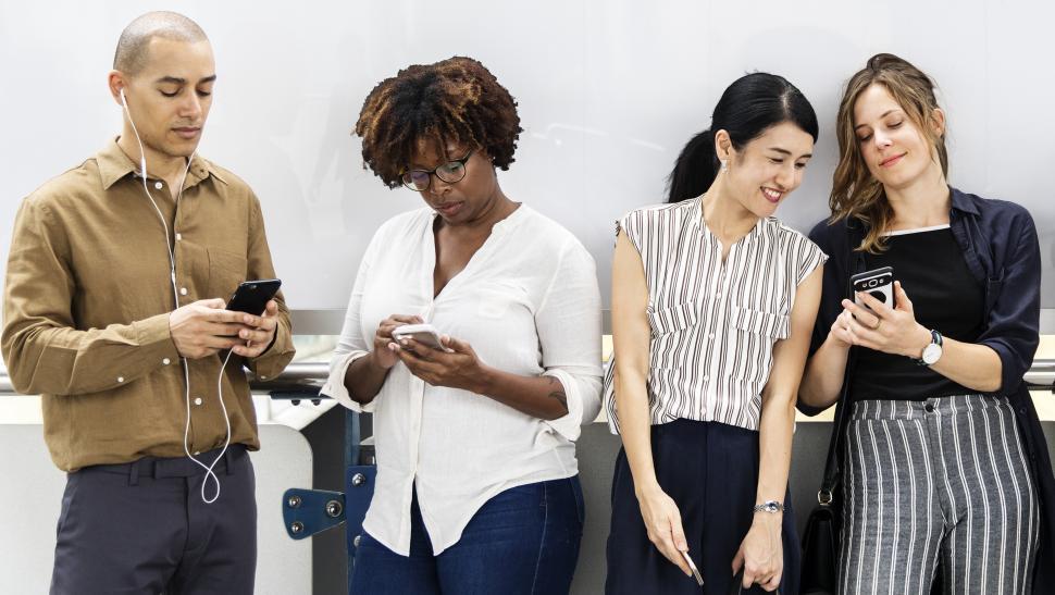 Free Image of People outside looking at their mobile phones 