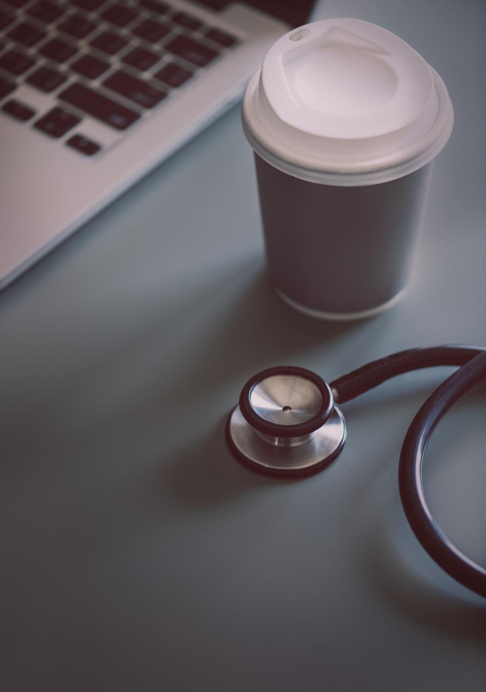 Free Image of Close up of a stethoscope alongside a coffee mug 