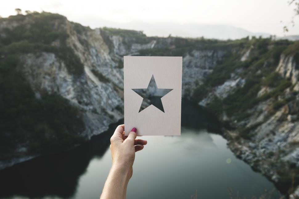Free Image of A hand holding a star shaped cardboard stencil 