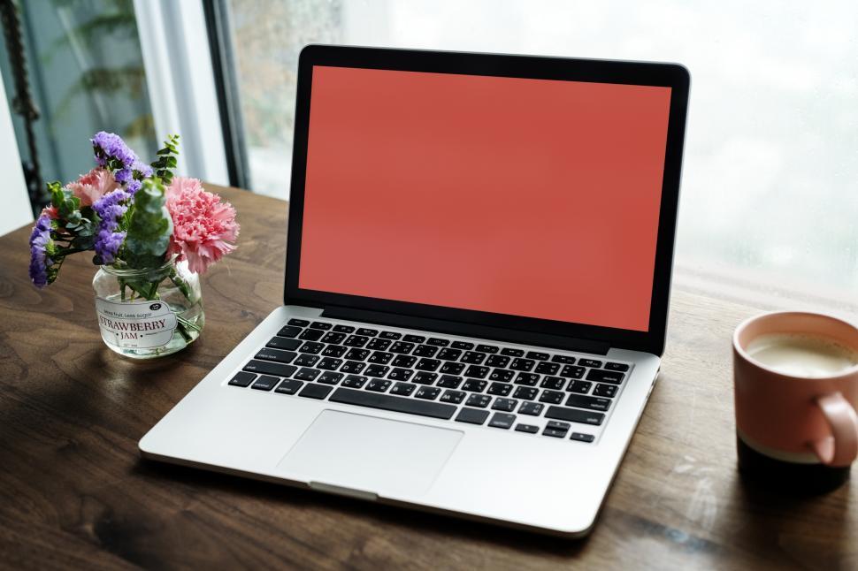 Free Image of Close up of open laptop on the table with mug of coffee 