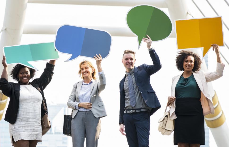 Free Image of A group of multiethnicity colleagues raising cardboard speech bubbles 