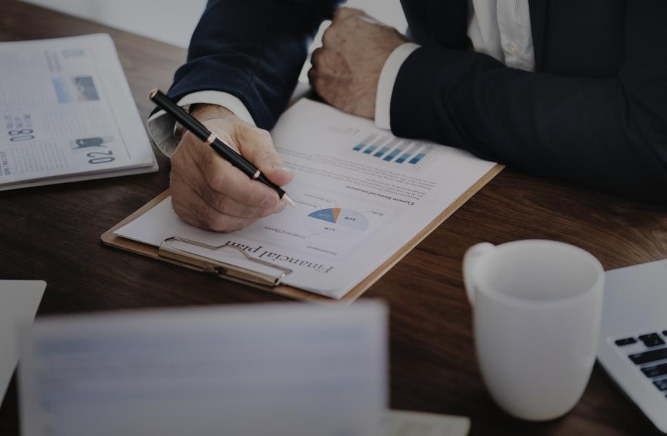 Free Image of Close up of a person s hand with a pen, checking financial plan 