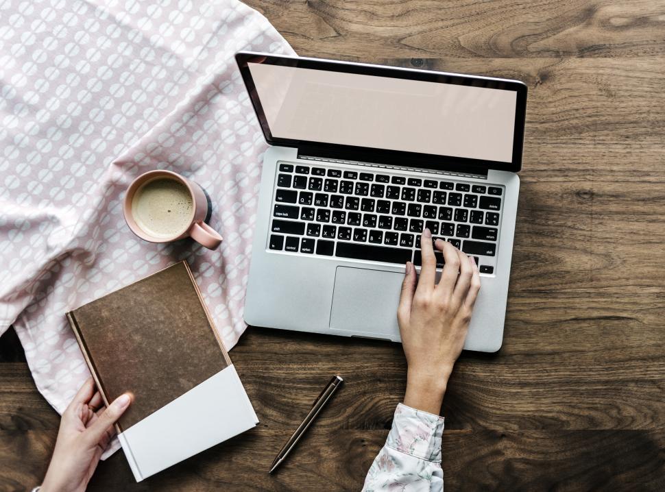 Free Image of Overhead view of a person type on laptop at work area 
