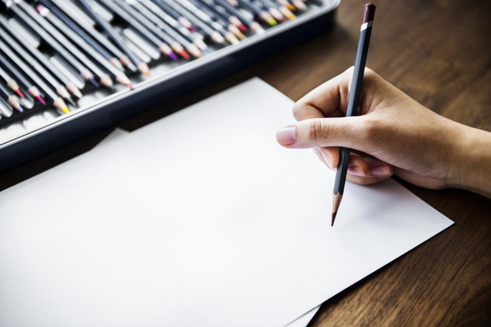 Free Image of Overhead view of a hand drawing on white sheet of paper 