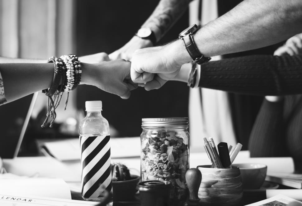 Free Image of Black and white photo of team giving Fist Bump in agreement 