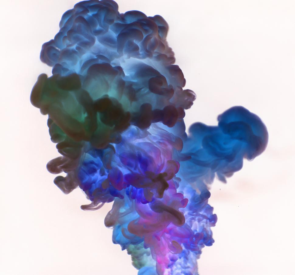 Free Image of Inverted color image of an abstract pattern of green, blue and purple ink swirling in water 