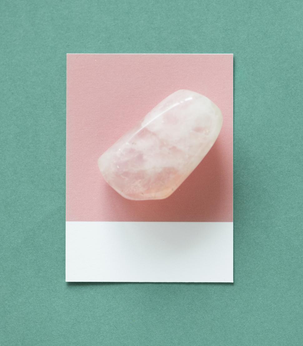 Free Image of Flat lay of an unpolished stone on darker green background 