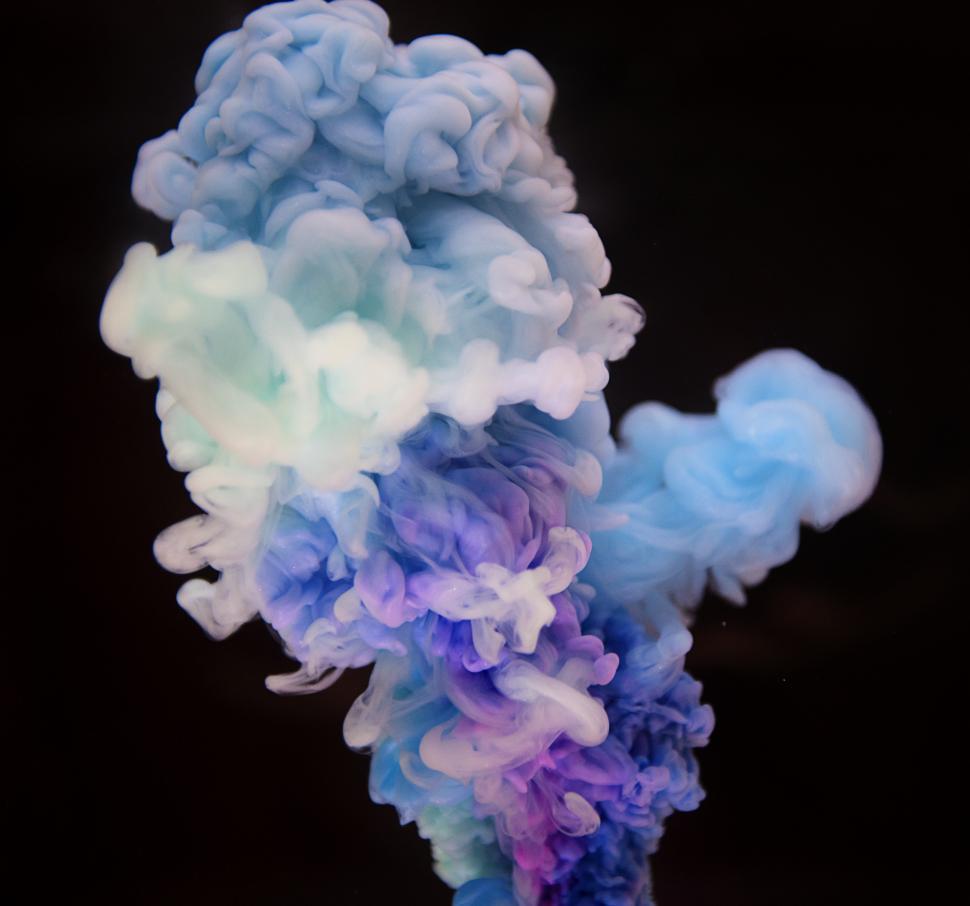 Free Image of An billowing pattern of blue,green and purple ink swirling in water 
