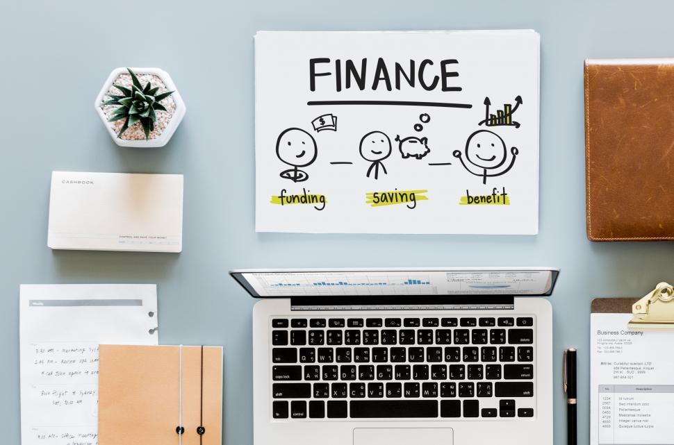 Free Image of Overhead view of laptop and Finance graphic in workspace 