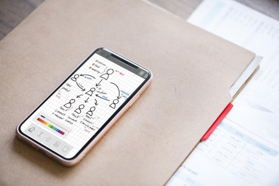 Free Image of Close up of a mobile phone on a file folders 
