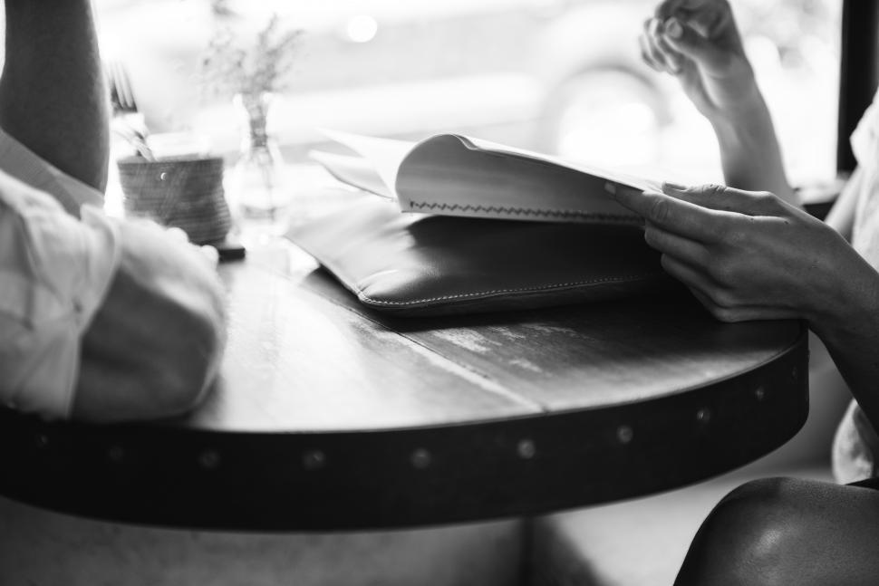 Free Image of Close up of two people s hands at a restaurant table 
