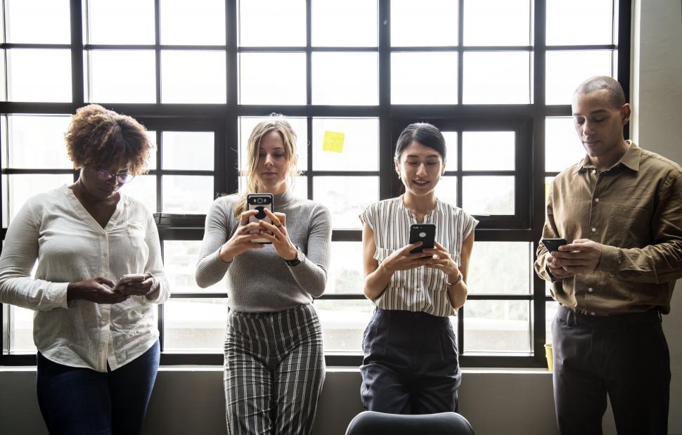 Free Image of Colleagues looking at their mobile phones 