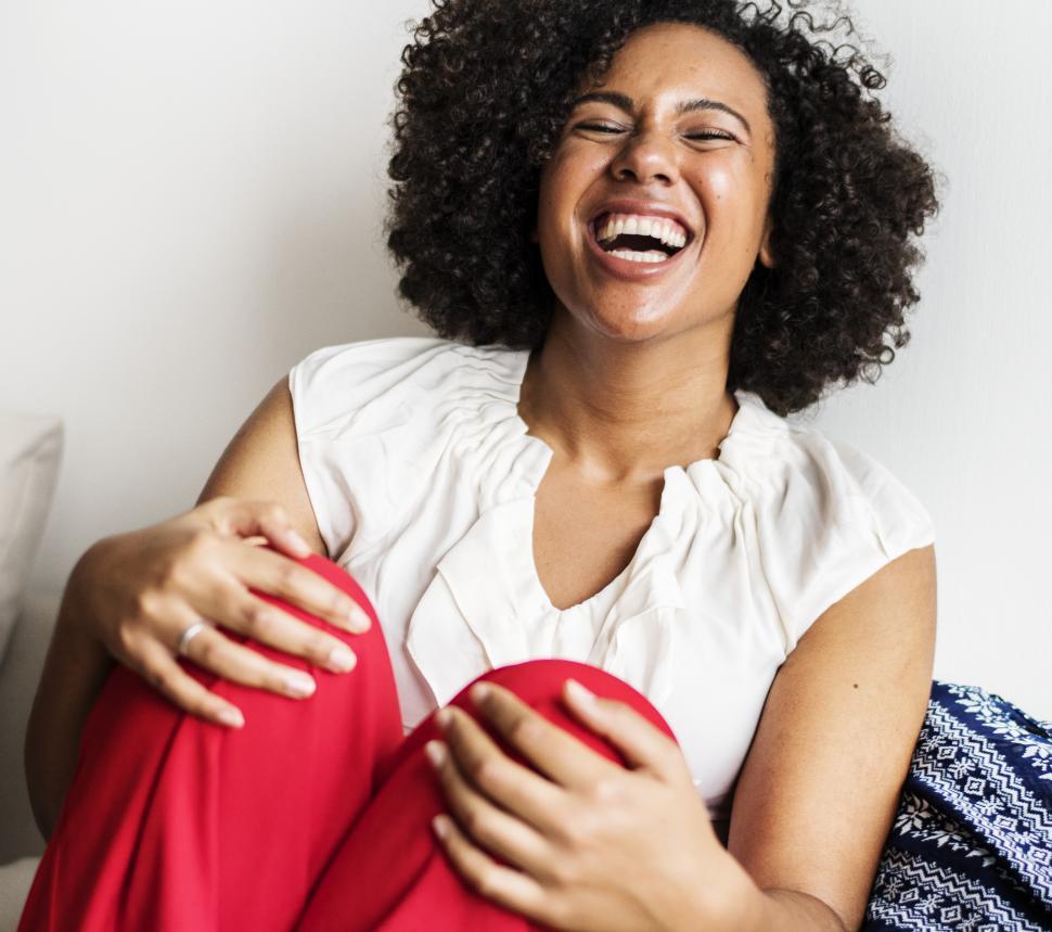Free Image of A young woman with curly hair laughing 