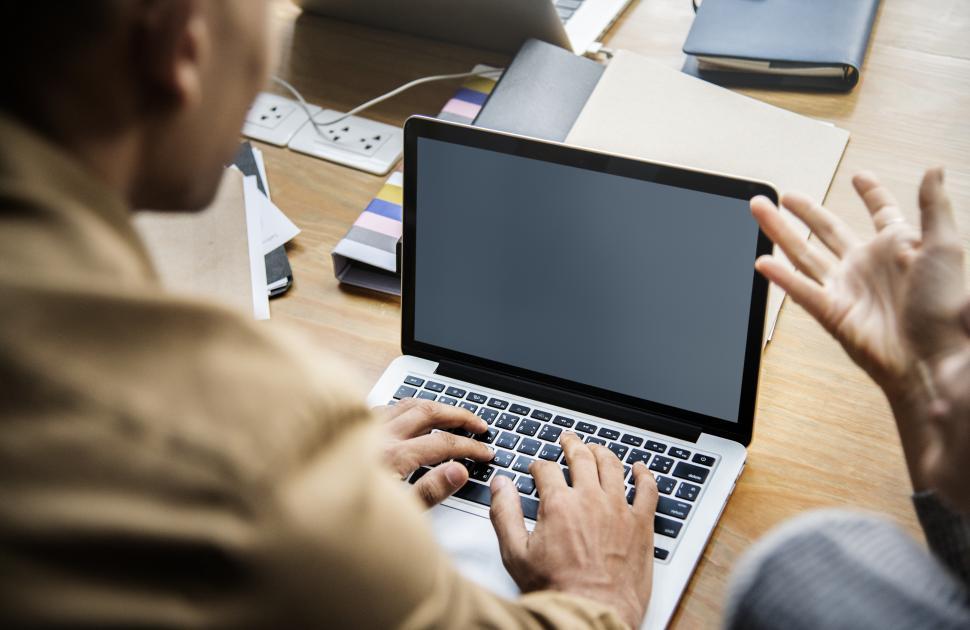 Free Image of Close up of a person working on laptop with blank screen 