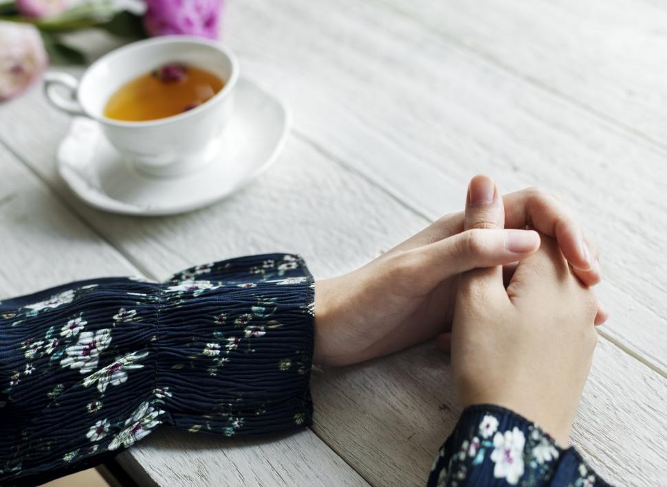 Free Image of Close up of a woman s hands on the wooden table 