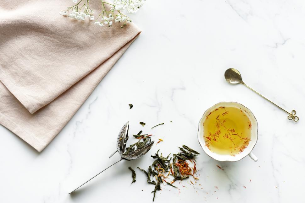Free Image of Flat lay of a cup of saffron tea on marble surface 