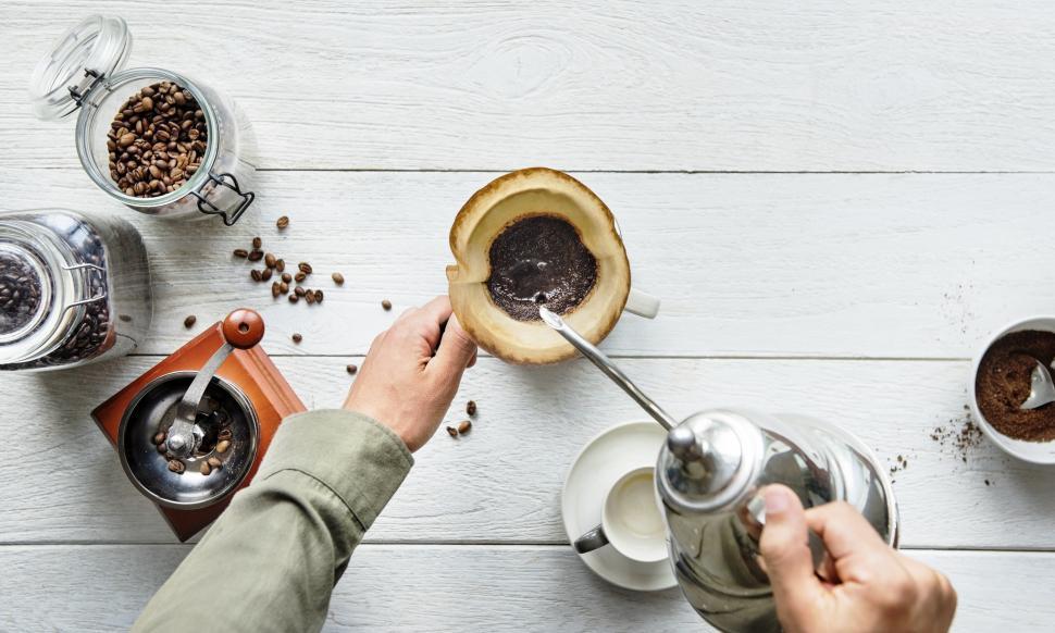 Free Image of Hot water being poured over coffee filter cone with coffee accessories 