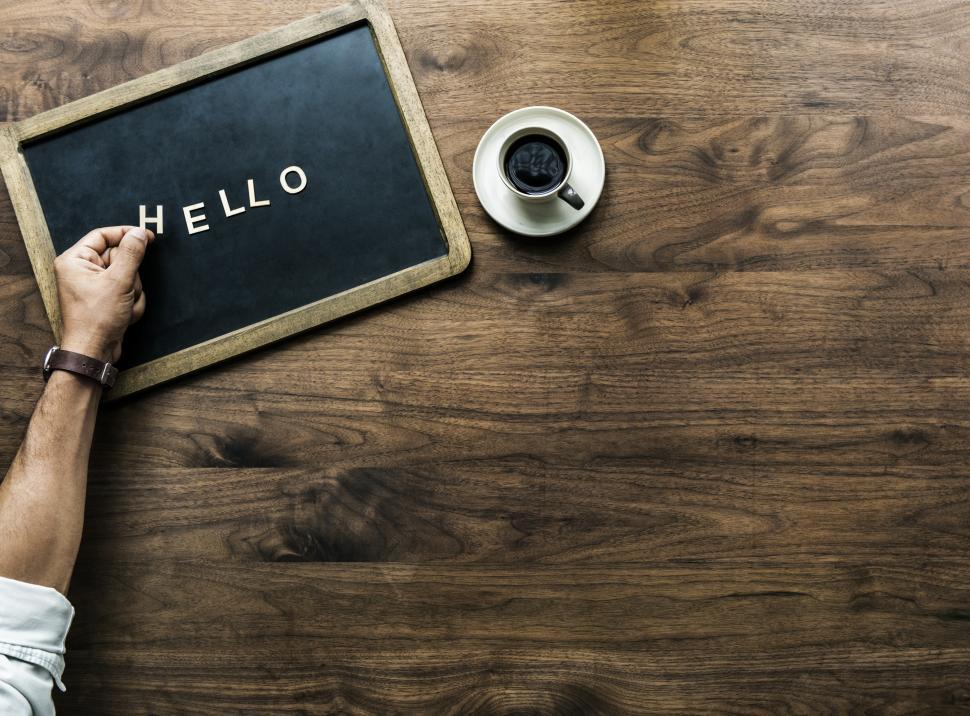 Free Image of Overhead view of the word HELLO laid out by plastic alphabet blocks on a slate 